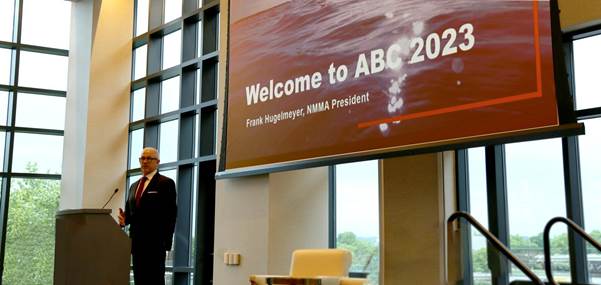 A person standing in front of a large screen

Description automatically generated